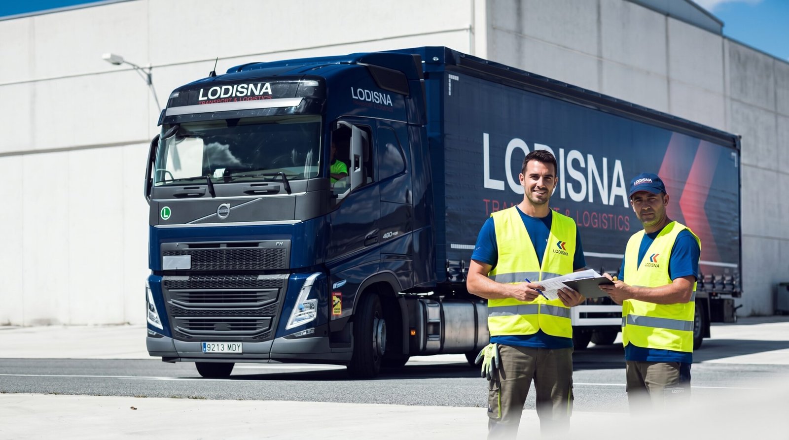 Doi șoferi TIR echipaj vară Lodisna lângă camion Volvo FH pe autostradă europeană